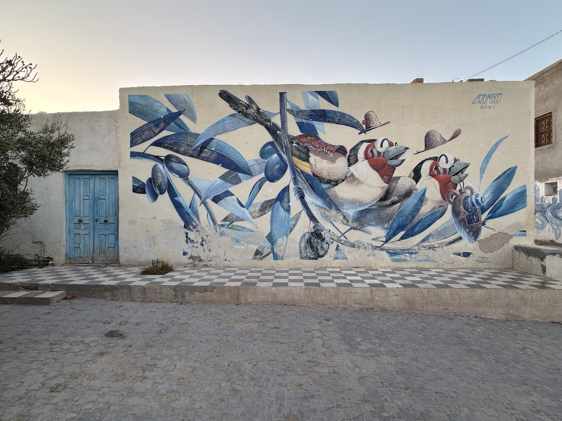 Fresque bleue et blanche couvrant la façade d’une maison d’Erriadh